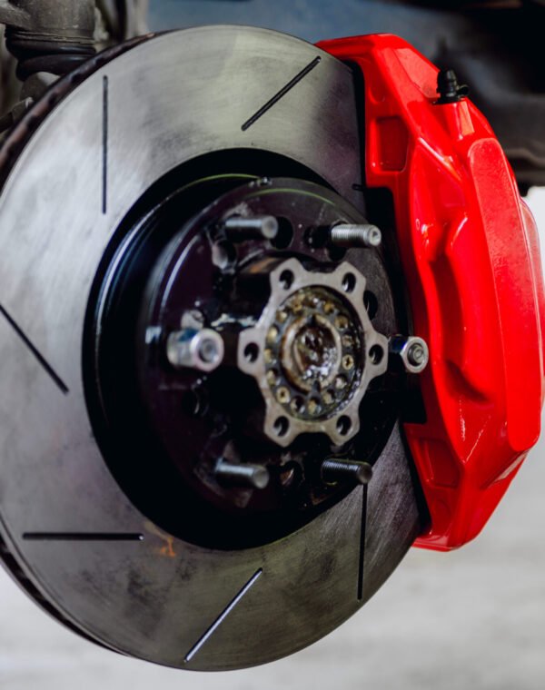 Large brake discs and large calipers provide better braking.The large calipers mesh properly with the discs.Car wheel and brake system.Red caliper.